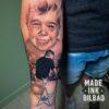 tatuaje cover en brazo con retratos