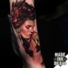 tatuaje bíceps cara chica cuervo cráneo